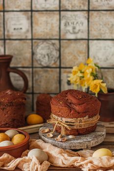 Kulich cake with yellow daffodil flowers, and painted eggs symbol of Traditional Russian Orthodox Easter.
