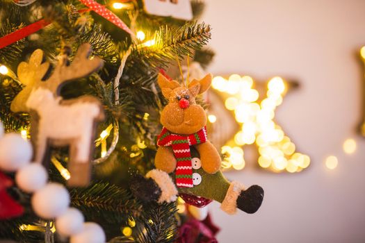 Christmas tree decorated with toys, balls, tinsel, funny baby animals , flowers close up on a background of green fir and of the magic.