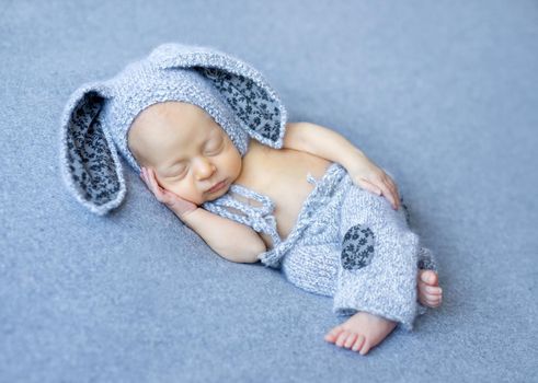 lovely newborn boy in blue hare suit with long ears