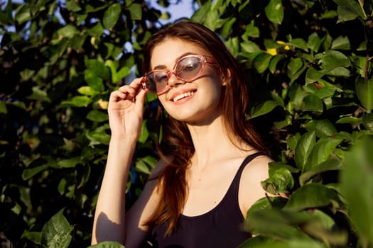 cheerful woman in black swimsuit green leaves nature posing. High quality photo