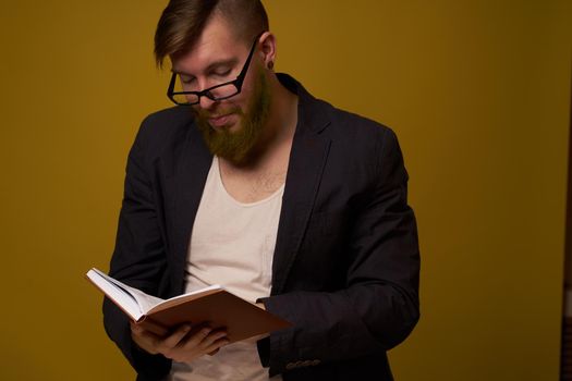 bearded man in a black jacket with a book in his hands education. High quality photo