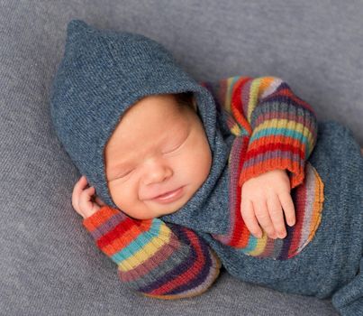 Lovely emotions of a fancy-dressed baby, sleeping on his side, closeup