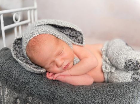 Lovely emotions os a sleeping baby in a funny hat, closeup