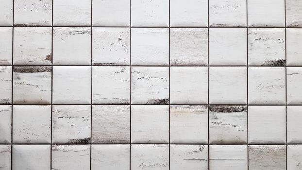 White aged tiles background. Seamless texture tiles. Old white small square dirty tiles on the wall
