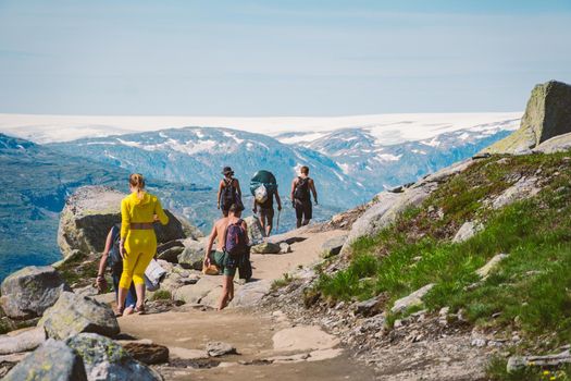 July 26, 2019. Norway tourist route on the trolltunga. People tourists go hiking in the mountains of Norway in fine sunny weather to thetrolltunga. Hiking backpack theme.