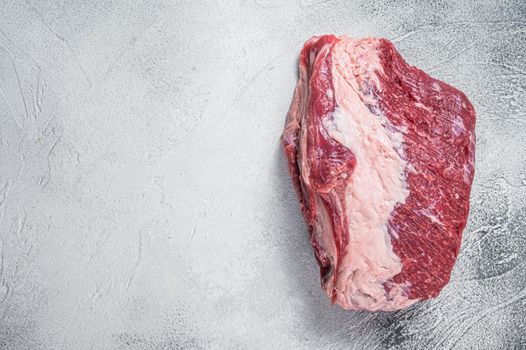 Raw Round beef meat cut on a butcher table. White background. Top view. Copy space.