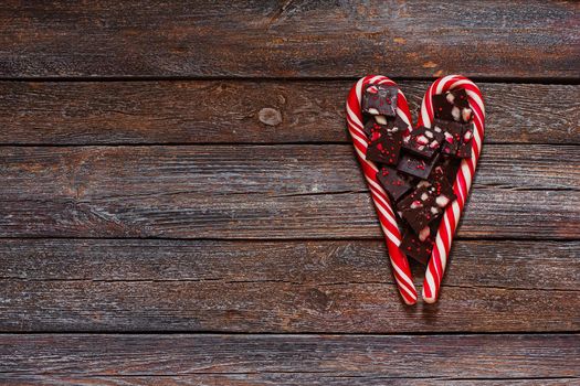 Red heart-shaped lollipop and chocolates of valentines day on wood texture background. Valentines day background.