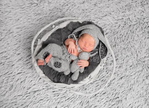 Adorable kid dressed as a rabbit, with a toy, resting topview