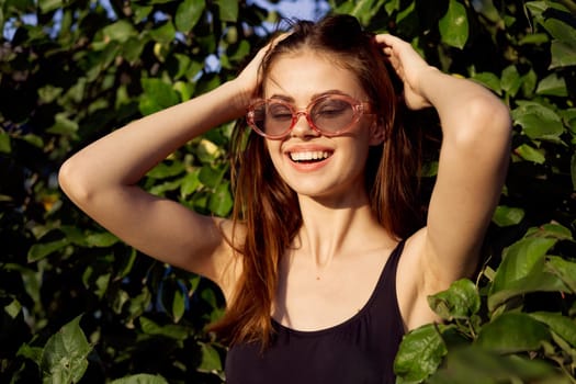 cheerful woman in black swimsuit green leaves nature posing. High quality photo