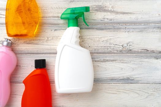 Set of different bottles of liquid detergents top view on grey background