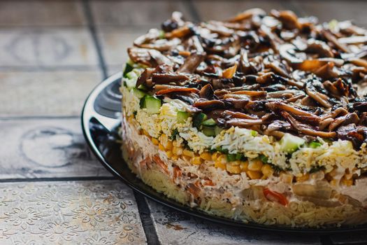 Salad with mushrooms, eggs, corns and carrots on the plate on rustic tiled table.