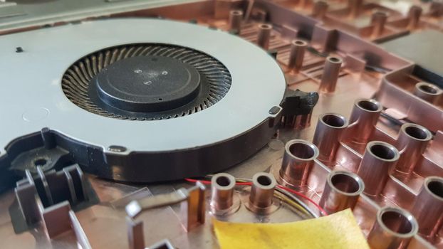 Closeup on a laptop cooler. Maintenance and prevention of the laptop cooling system. Electronic device repair concept. Dust and dirt on the computer fan. Disassembly of the computer
