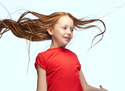 girl with red hair posing red t-shirt childhood. High quality photo