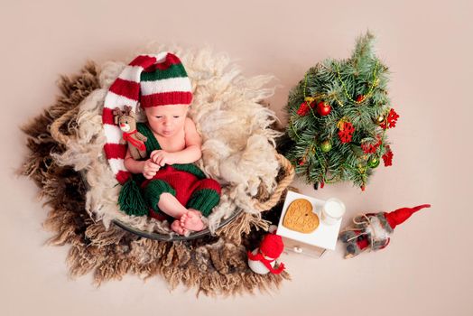 Top view of baby in knitted suit with new year decortions