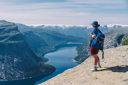 Traveling Lifestyle adventure vacations in Norway aerial view landscape. Hike In Norway. Amazing nature view on the way to Trolltunga. Traveller Standing On Famous Norwegian Natural Sight Trolltunga.