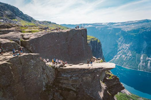 July 26, 2019. Norway tourist route on the trolltunga. People tourists go hiking in the mountains of Norway in fine sunny weather to thetrolltunga. Hiking backpack theme.