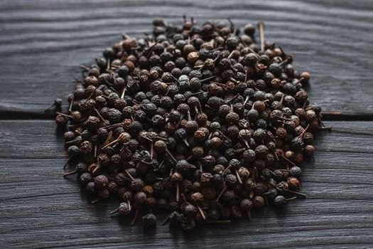 Black pepper grains, peppercorns seeds on a background close up macro