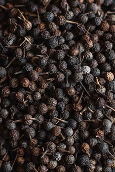 Black pepper grains, peppercorns seeds on a background close up macro