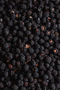 Black pepper grains, peppercorns seeds on a background close up macro