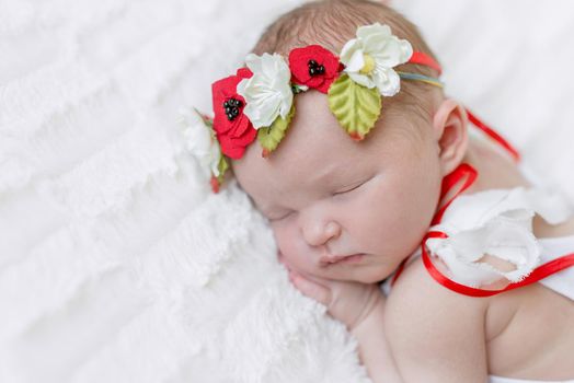 Sweet girl in bright Ukrainian colorful hairband and a white suit sleeps tight on her side