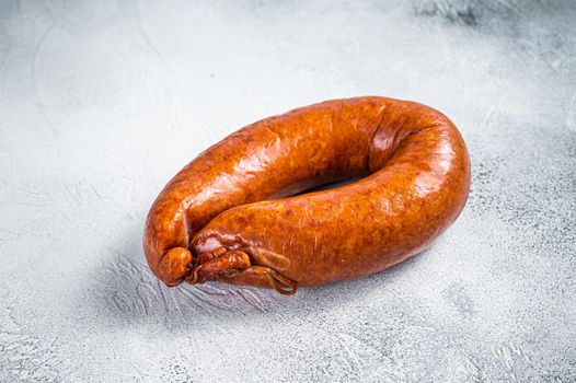 Smoked sausage on a white rustic table. White background. Top view.