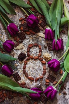 8 march, international woman's day, eight from cocoa beans with purple tulips and handmade chocolates around.