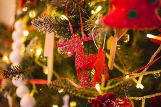 Handmade Christmas decorations: felt Christmas moose. Christmas toy of red color in the form of an animal made of cloth on a tree