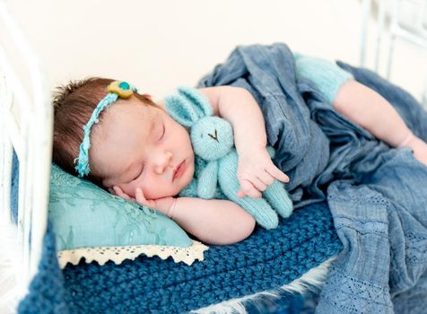 cute newborn baby girl sleeping in a little bed