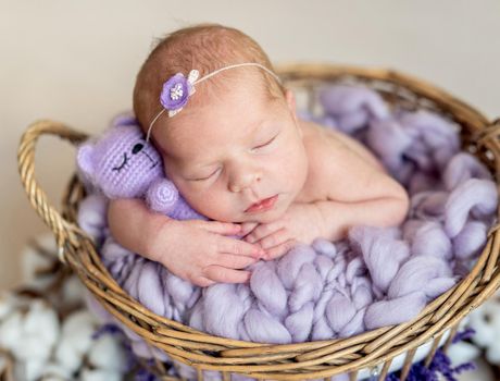 Funny little new born girl hugging teddy bear, close up