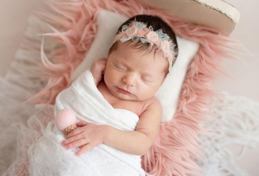 Little cutie infant girl sleeping on baby bed