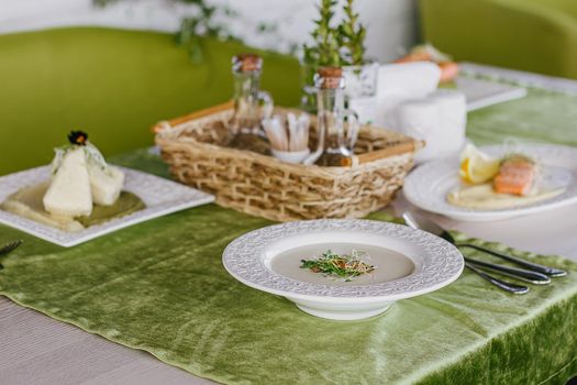 Cheese soup with salmon in green interior background.