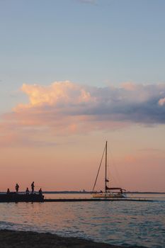 Yacht sailing against sunset. Holiday lifestyle landscape with skyline sailboat and two seagull. Yachting tourism - maritime evening walk. Romantic trip on luxury yacht during the sea sunset.