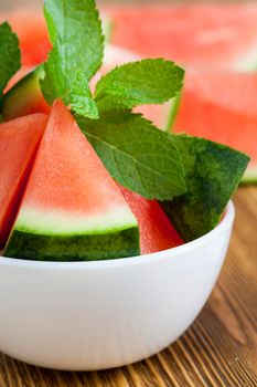 sliced red watermelon with green mint leaves as a dessert, closeup