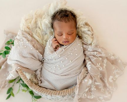 African newborn baby in basket covered with sheets