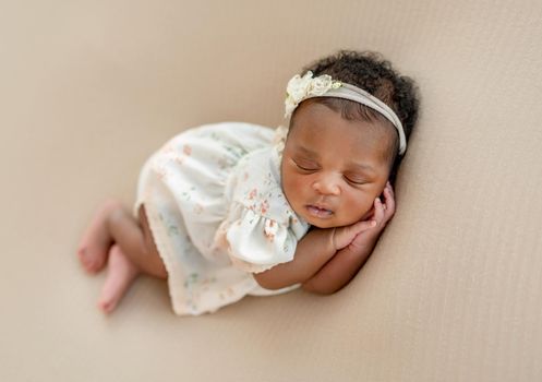 Cute newborn baby sleeping on side with crossed legs