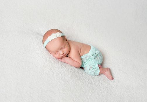 Sweet newborn girl sleeping and hugging her plush elephant toy. Little child girl sleeping with toy on soft rug