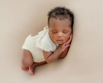 Innocent infant asleep with arms under head