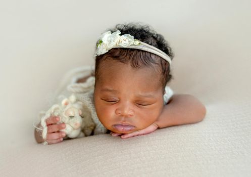 Sleppy African newborn girl with plush toy