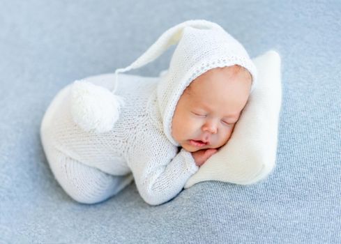 Peaceful sleep of newborn in white bodysuit