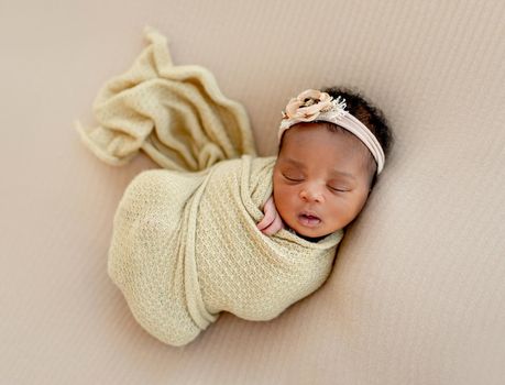 African newborn Baby girl sleeping calm wrapped up in blanket