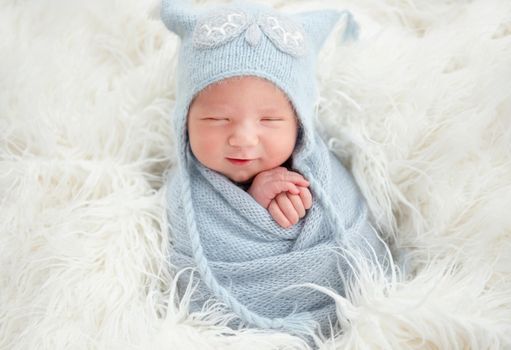 Cute newborn in blue knitted suit