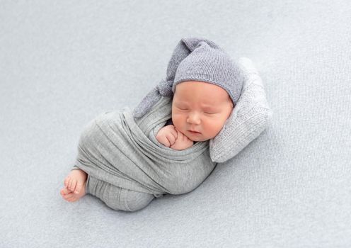 Adorable newborn resting on tiny pillow