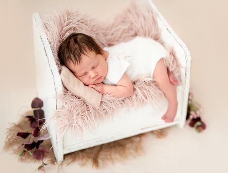 Charming newborn sleeping in tiny bed