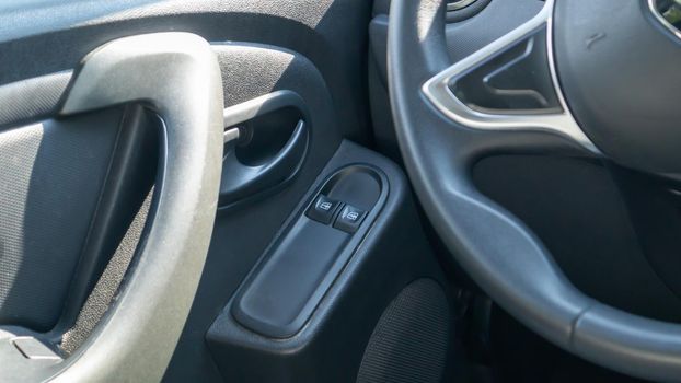 The front and rear power window buttons lower or close the car windows. Elements and controls of car windows. Detailing the car. Interior details of the door handle with power window controls