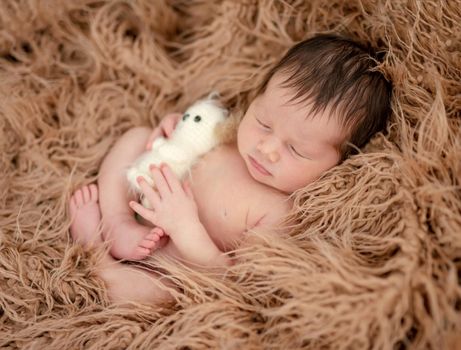 Charming naked newborn calmly sleeping