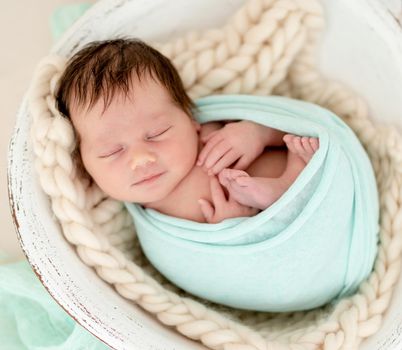 Smiling newborn girl sleeping in cradle