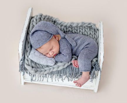 Cute newborn sleeping on tiny bed