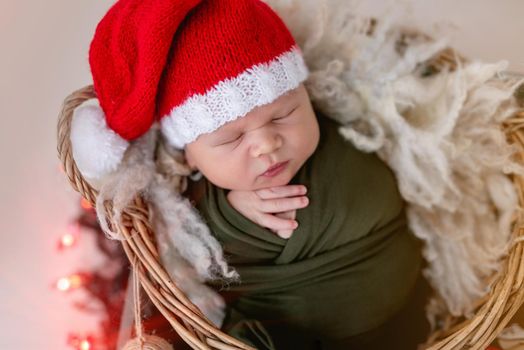 Lovely newborn wearing santa hat in christmas decorations