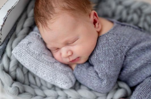 Cute newborn sleeping on tiny bed