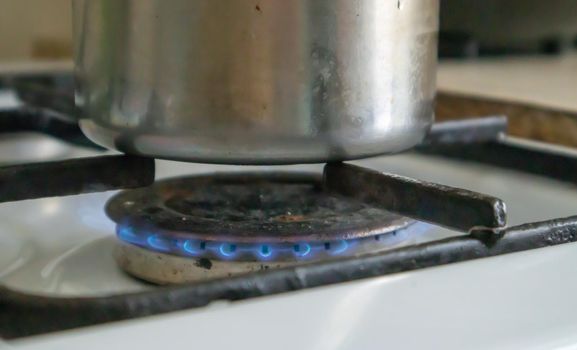 Dirty gas stove in the kitchen for cooking with vegetable oil stains and burnt food debris on the surface, close-up. Selective focus. Grease-covered gas hob in the kitchen. Gas included